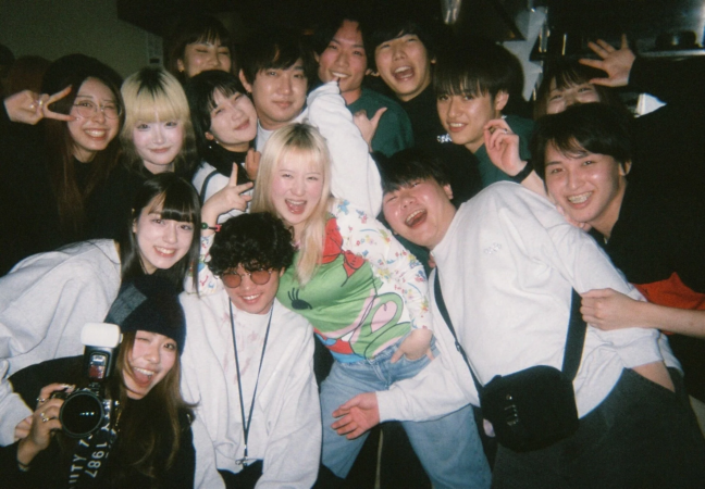 多くの若者が笑顔で集まり、楽しそうにポーズをとっている集合写真