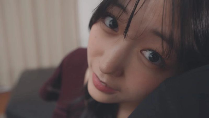 若い女性の顔がクローズアップで写されており、カメラに優しい視線を向けている