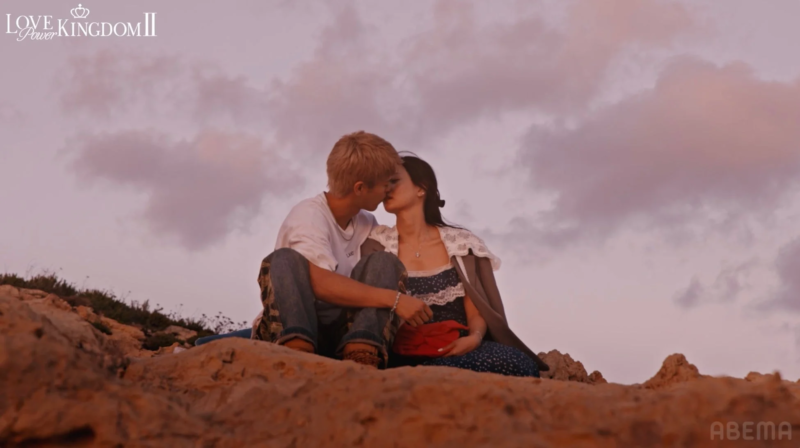 夕暮れの丘の上でキスを交わすカップル