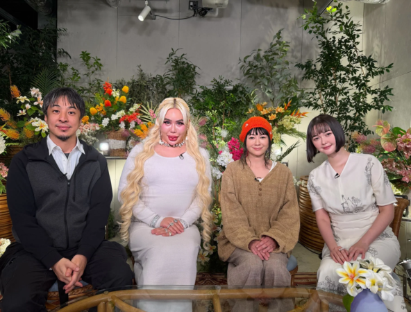 花や植物で飾られた背景の前に、4人の男女が座っている集合写真。皆カメラに向かって穏やかな表情をしており、和やかな雰囲気が伝わります。