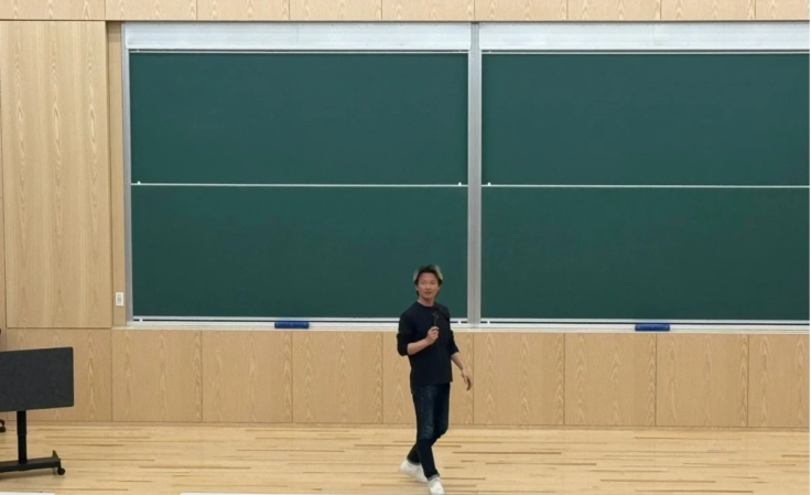 黒板の前に立つ男性