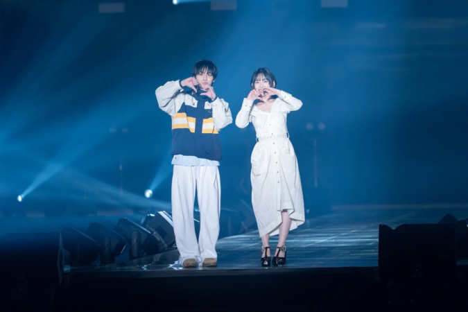 ステージ上の男女がハートポーズ