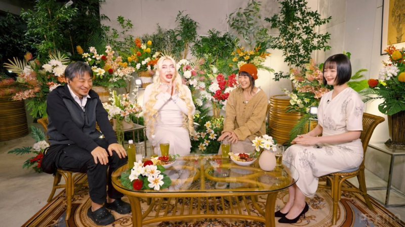 花と植物で装飾されたスタジオで会話する見届け人たち