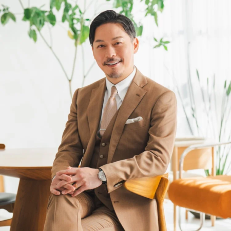 茶色のスリーピーススーツを着たアジア人男性