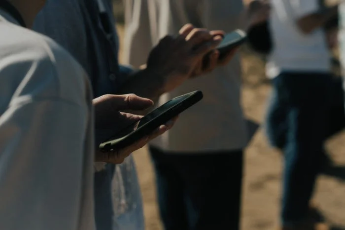 スマートフォンを操作する人々の手元