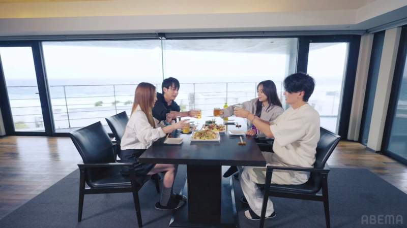 オーシャンビューの部屋で食事をしながら乾杯する男女4人