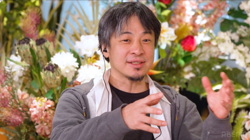 花を背景に話す石丸伸二さん