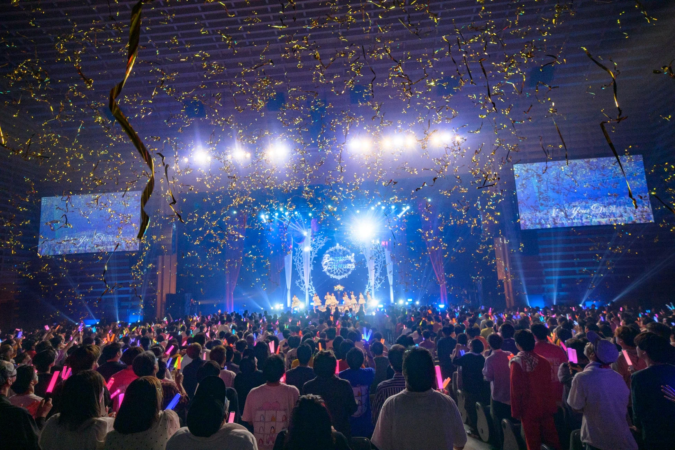 大勢の観客がペンライトを振るライブイベントの様子