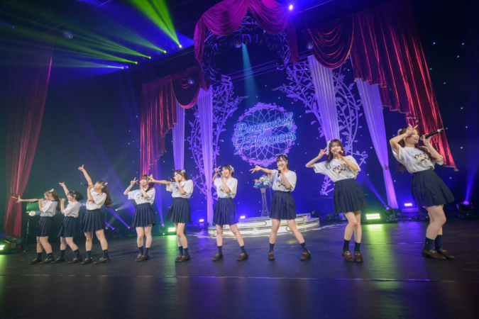 華やかな照明に照らされたステージでパフォーマンスするアイドルグループ