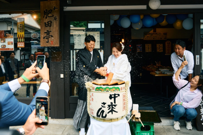 鏡開きを行う新郎新婦と参加者たち