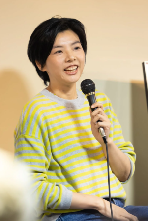 マイクを持って話す女性