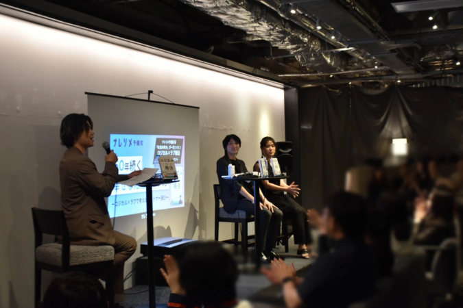 イベント会場でプレゼンテーションを行う男性