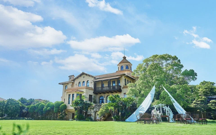 広々とした芝生と美しい洋館が特徴の結婚式場の風景。