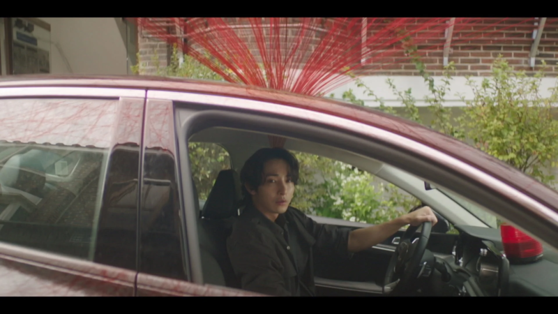 車に乗る男性と赤い糸
