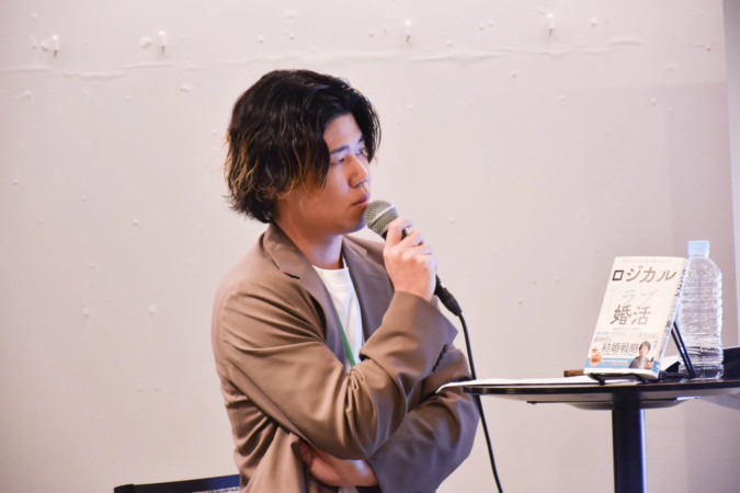 トークイベントでマイクを持つ男性登壇者