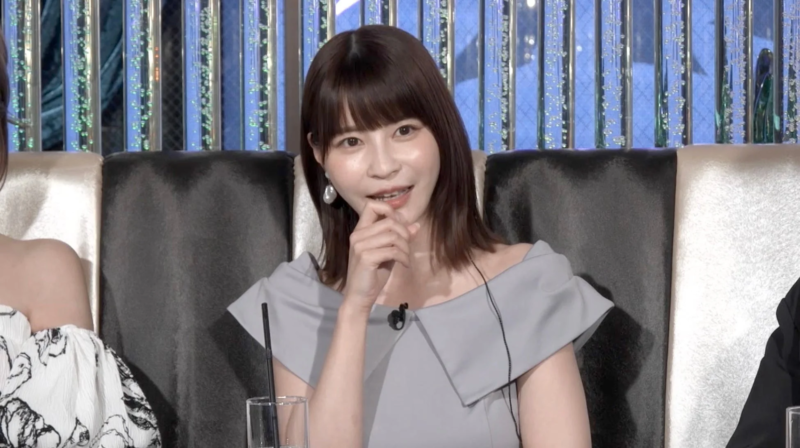 笑顔で指を口元に当てている女性