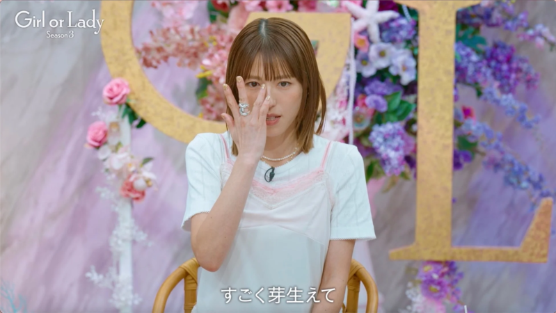 感情的な表情で顔の一部を覆う女性