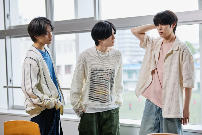 窓際に立つ3人の若者